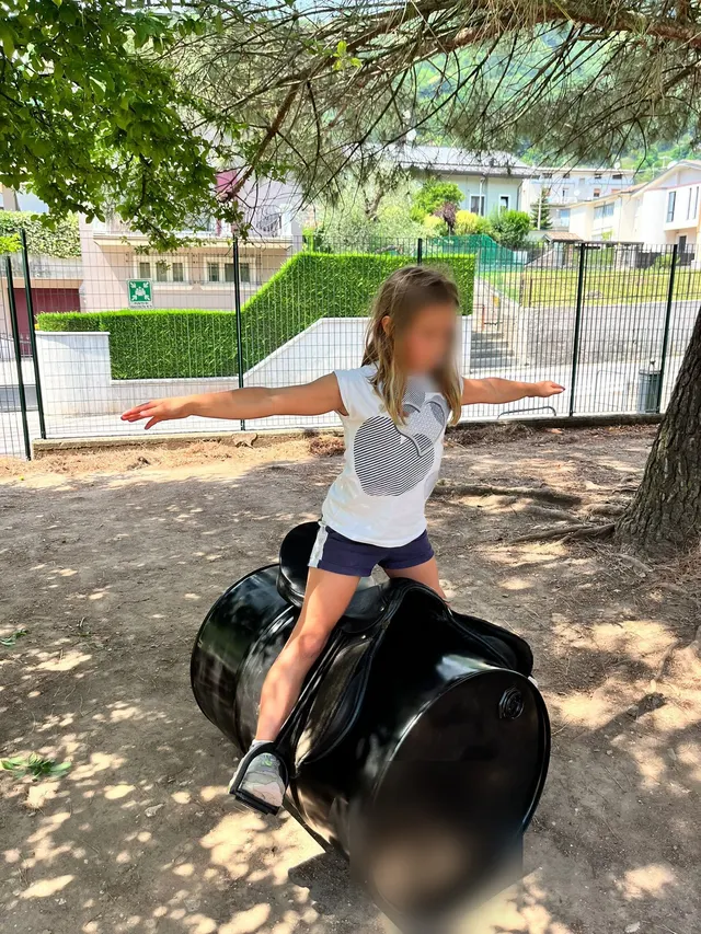 Bambina in equilibrio, a braccia aperte, durante un gioco