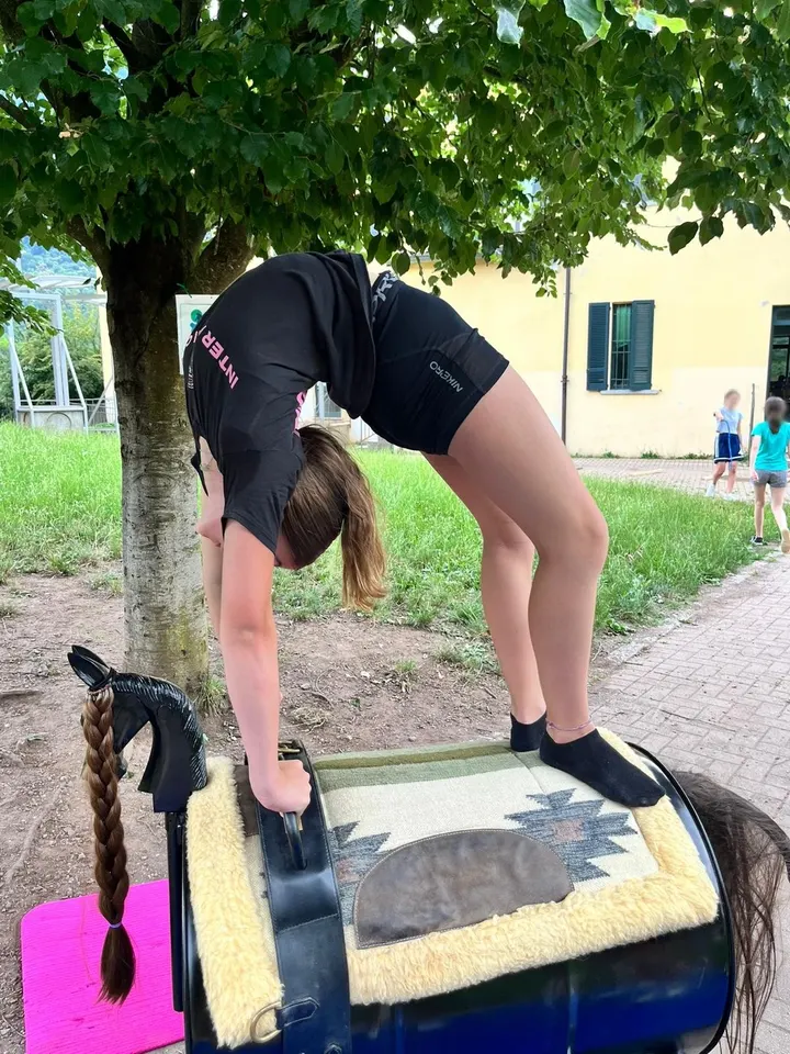 Una bambina accanto a un pony pezzato